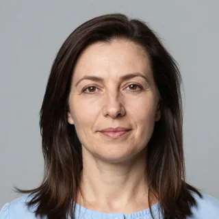 Портрет преподавателя математики: женщина с тёмными волосами до плеч в голубой блузке